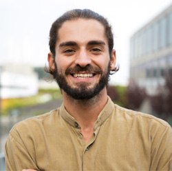 Bearded man standing outside in city and smiling