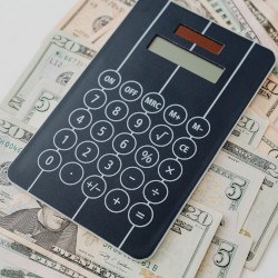 Calculator and cash spread out on a table